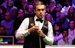 Ronnie O'Sullivan chalking his cue at a snooker match.