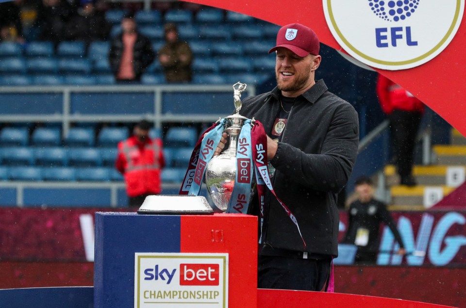 BURNLEY, ENGLAND - MAY 08: Burnley owner JJ Watt carries the league winner's trophy to the stage during the Sky Bet Championship between Burnley and Cardiff City at Turf Moor on May 8, 2023 in Burnley, United Kingdom. (Photo by Alex Dodd - CameraSport via Getty Images)