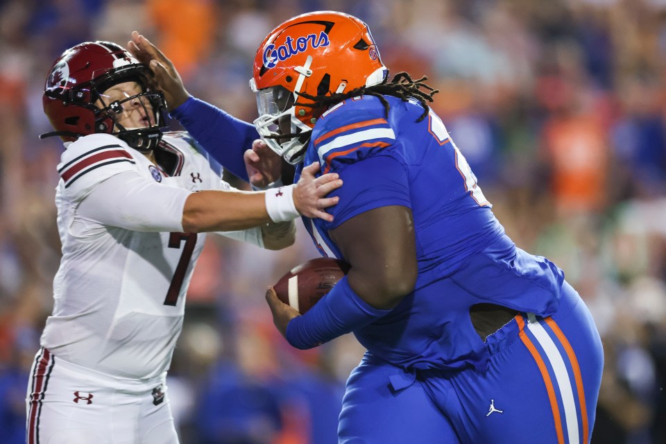 GAINESVILLE, FLORIDA - NOVEMBER 12: Spencer Rattler #7 of the South Carolina Gamecocks is stiff armed by Desmond Watson #21 of the Florida Gators after he recovered a fumble during the second half of a game at Ben Hill Griffin Stadium on November 12, 2022 in Gainesville, Florida. (Photo by James Gilbert/Getty Images)